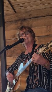Musician playing the guitar and singing at a microphone
