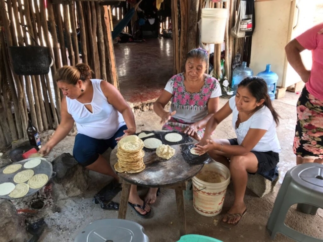 Three women making tortillas