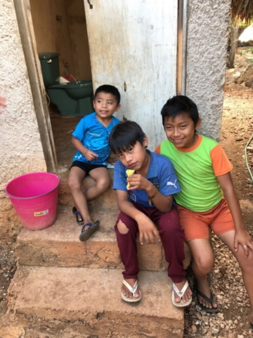 Three Mayan boys sitting on doorstep