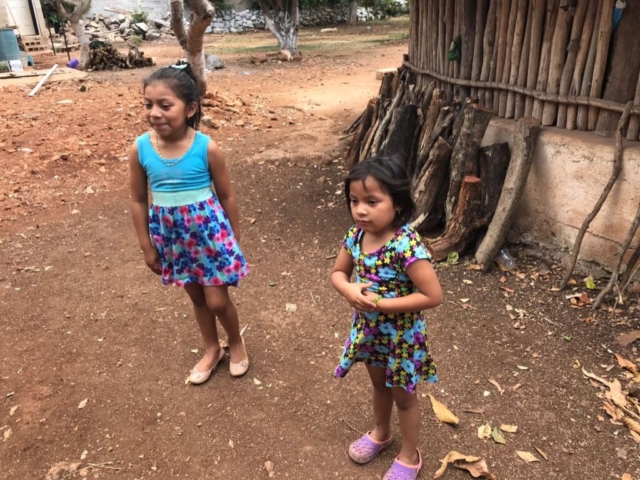 Two young Mayan girls standing outside