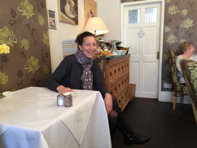 A Welsh woman sitting at a table, smiling